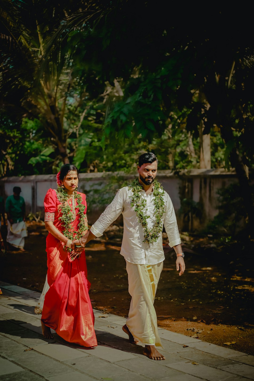 Walking hand in hand with wedding garlands