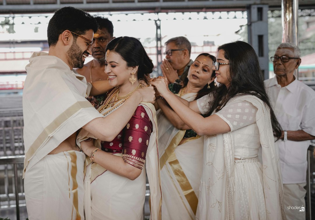 The couple at a temple wedding, surrounded by family