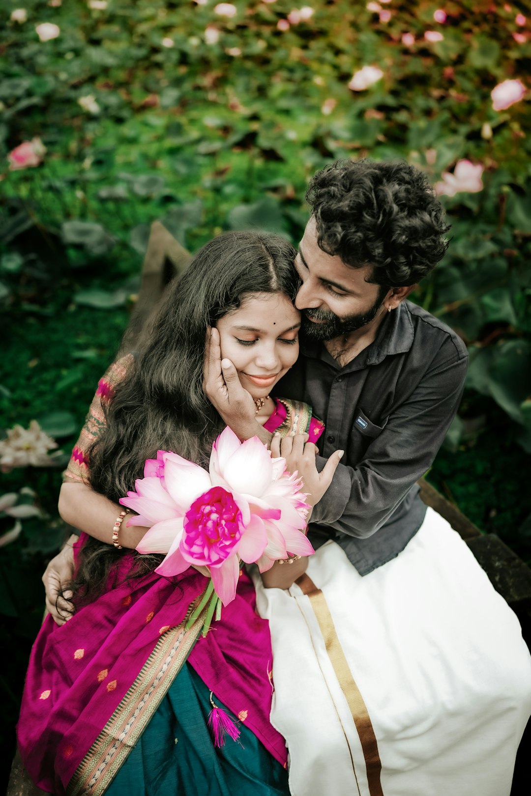 The couple with pink lotuses, smiling