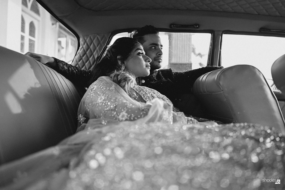The couple in the wedding car, in black and white